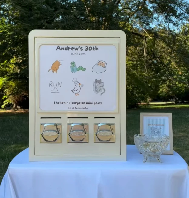 The in a memento vending machine at a 30th birthday party, showing six doodle designs and the sign '1 token = 1 surprise mini print'